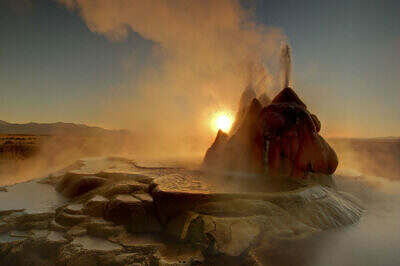 Fly Geyser schießt kochende Wasserfontänen ins Gegenlicht der Morgensonne in der Black Rock Desert von Nevada.