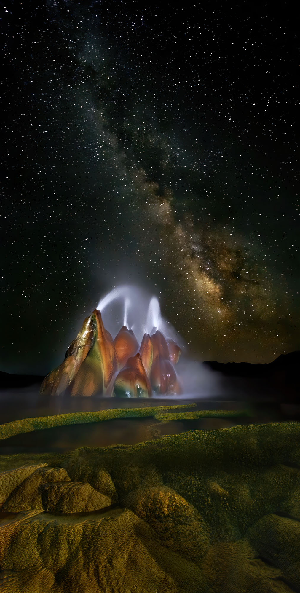 Nächtlicher Fly Geyser Ausbruch unter den Sternen der Milchstraße in der Black Rock Desert von Nevada