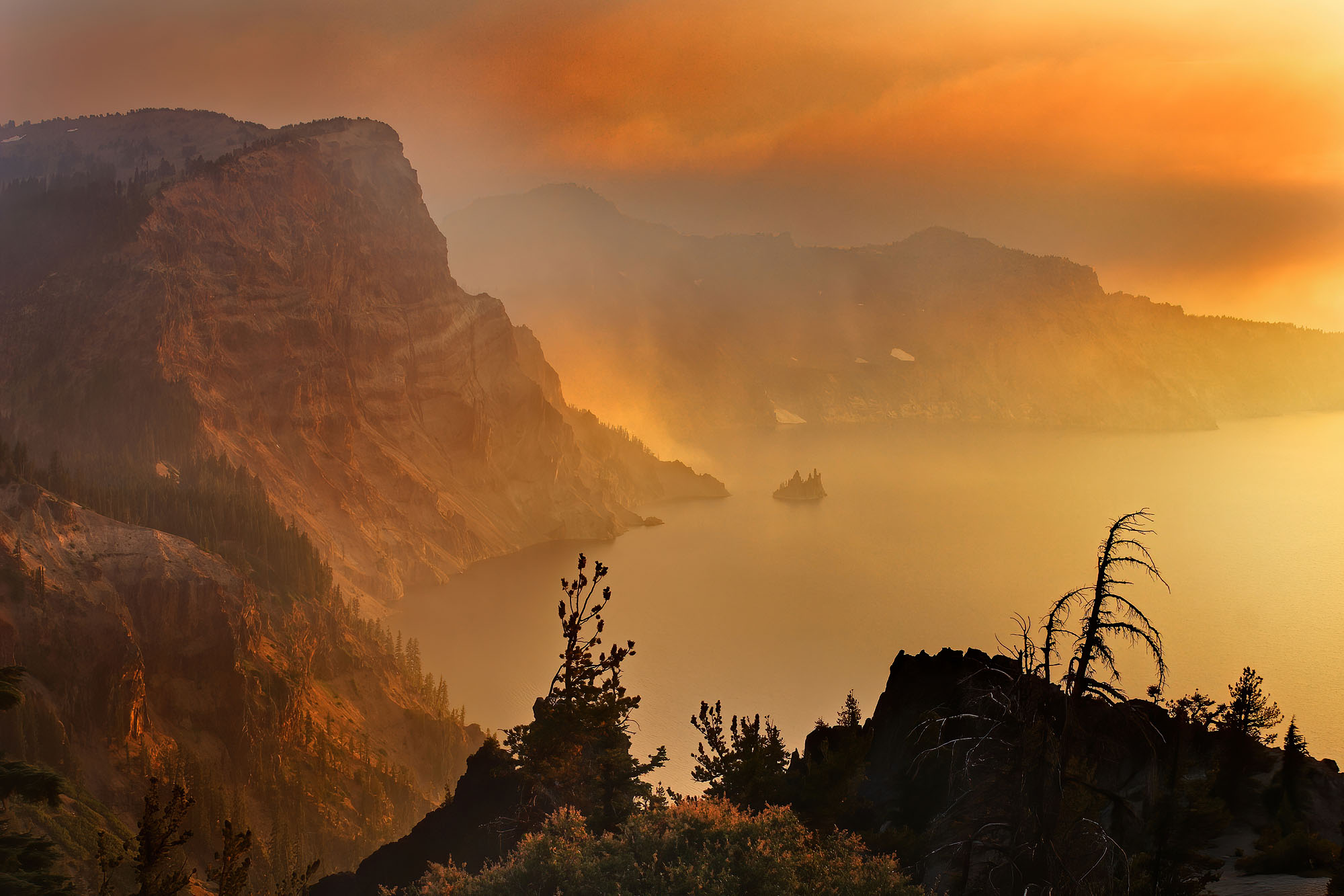 The Crater Lake volcanic caldera in the Cascade Range in Oregon is shrouded in the smoke of a wild fire ignited by lightning strike
