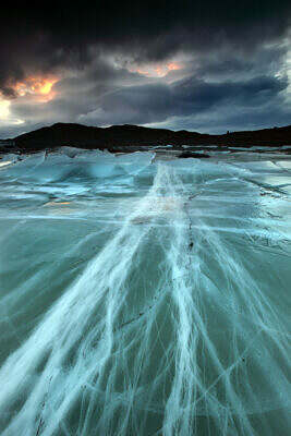 Frozen Svínafellsjökull lagoon in Skaftafell, Iceland, with parallel ice cracks caused by the moving glacier