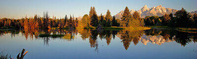 The Grand Teton Range in Wyoming is mirrored at sunrise in Oxbow Bend at Schwabachers Landing in Jackson Hole