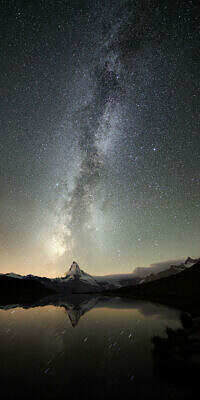 The Matterhorn in Zermatt, Switzerland, under the Milky Way is reflecting in nighttime Stellisee lake