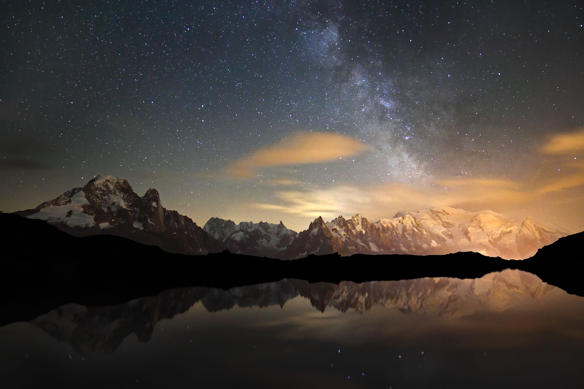 Nighttime Mont Blanc in the French Alps reflecting in alpine lake Lac de Cheserys above Chamonix with the Milky Way