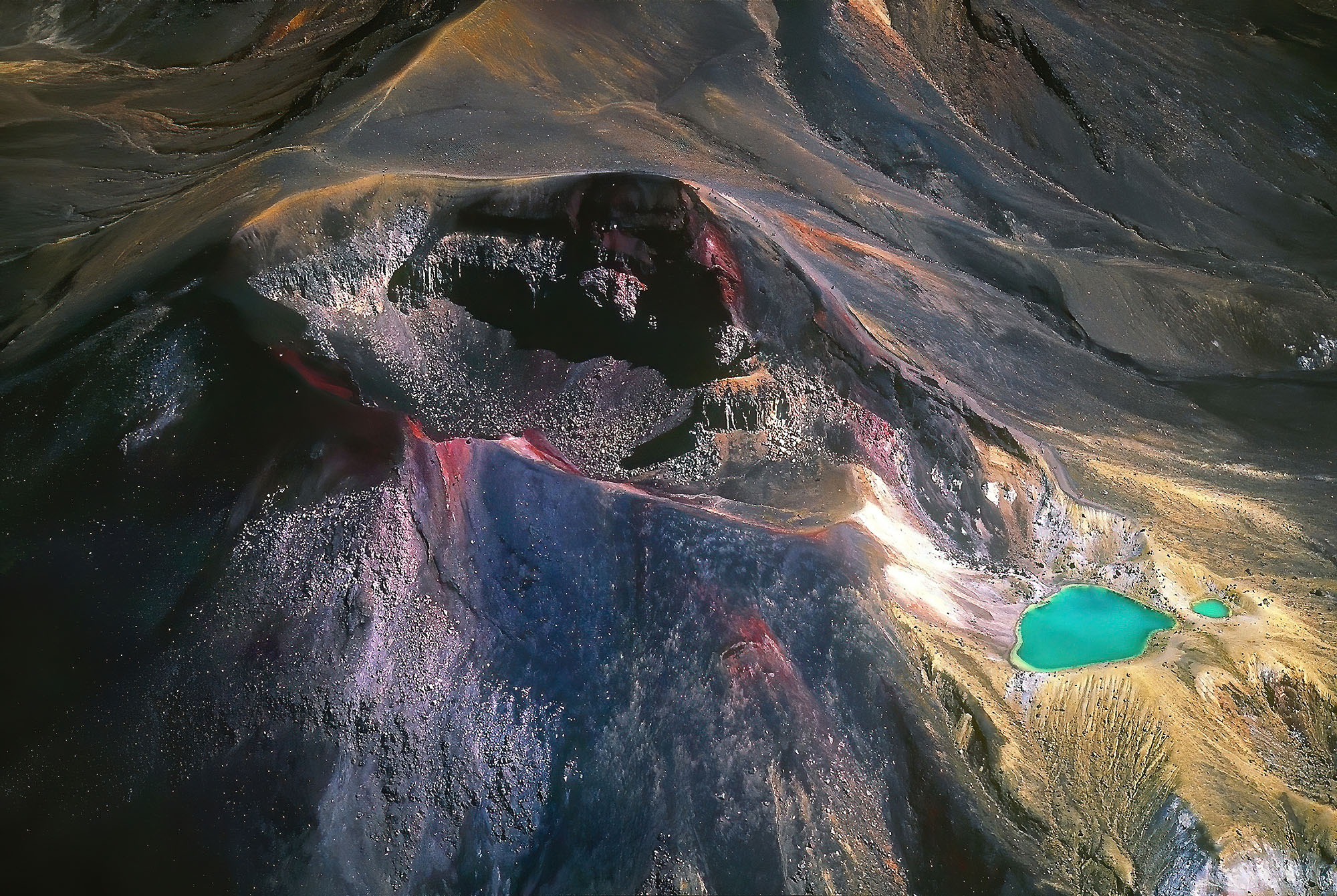 The aerial view into Red Crater with the green Emerald Lakes on the summit of Mount Tongariro in New Zealand reveal the extraordinary and ever-changing beauty of explosive volcanism.
